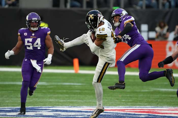 New Orleans Saints receiver Chris Olave (12) catches the ball between Minnesota Vikings defenders Camryn Bynum (24) and Eric Kendricks (54). Mandatory Credit: Kirby Lee-USA TODAY